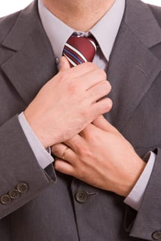 Business man fixing his tie, isolated over white