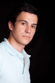 Young boy posing isolated over black background