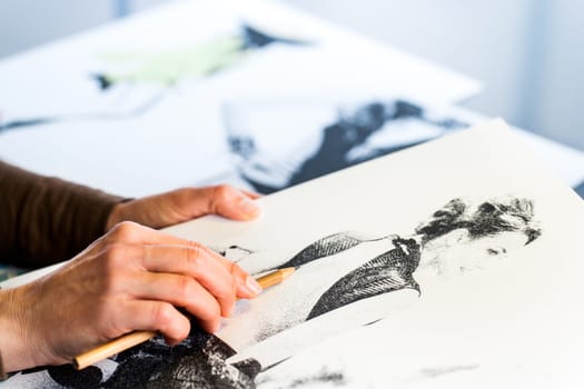 Extreme close up of female fashion designers hand creating fashion sketch.