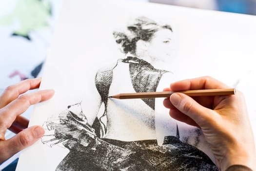 Extreme close up of female hands making fashion sketch.