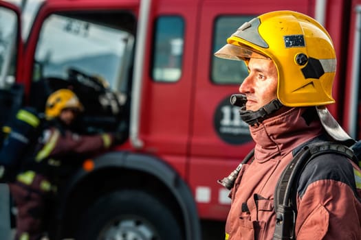 Close up portrait of Fireman staring at danger in front of fire truck.