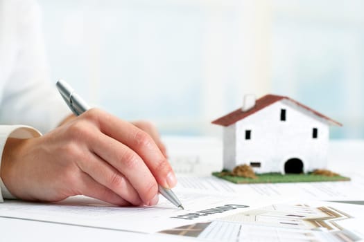 Extreme close up of female hand signing real estate contract.