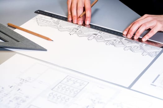 Macro close up of architects hands working on design document.