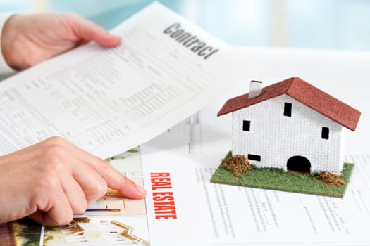 Close up of female hands reviewing real estate property documents.