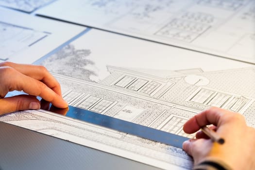 Macro close up of Hands measuring detail on house plan.