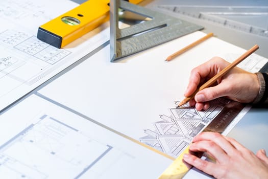 Macro close up of architect planning home layout with pencil.