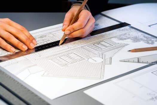Macro close up of quantity surveyor working on architectural layout.