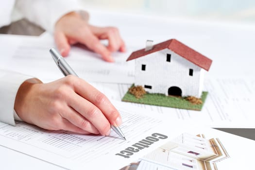 Close up of female hand reviewing real estate contract.