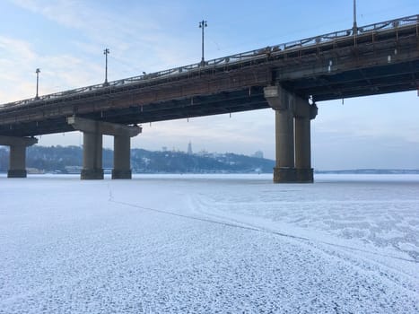 Paton bridge over frozen Dnipro river. Pechersk Lavra in the background. Kyiv, Ukraine