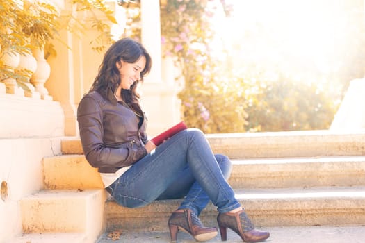 Young woman reading a book and relaxing at the park