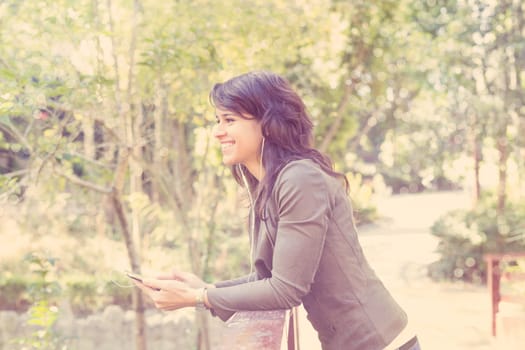 Young woman listening to music at the park