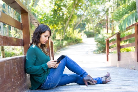 Young woman relaxing at the park with a tablet computer