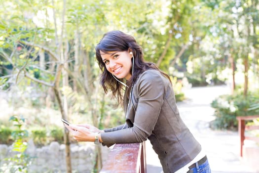 Young woman listening to music at the park
