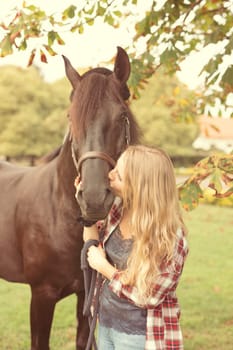 Beautiful and natural young woman spending sometime with her horse