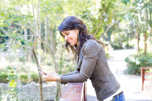 Young woman listening to music at the park
