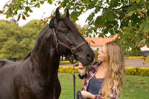 Beautiful and natural young woman spending sometime with her horse