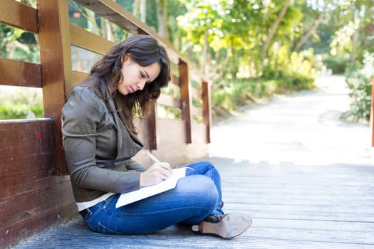 Young woman reading a book and relaxing at the park