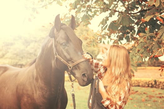 Beautiful and natural young woman spending sometime with her horse