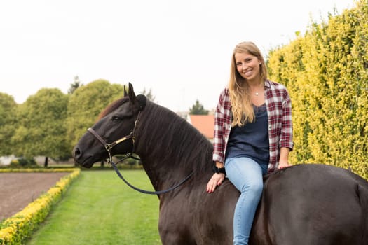 Beautiful and natural young woman spending sometime with her horse