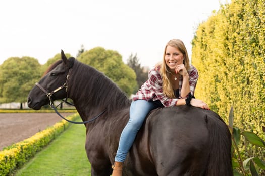 Beautiful and natural young woman spending sometime with her horse