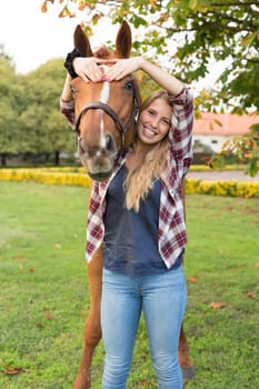 Beautiful and natural young woman spending sometime with her horse