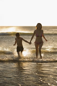 Woman running with her son on the beach