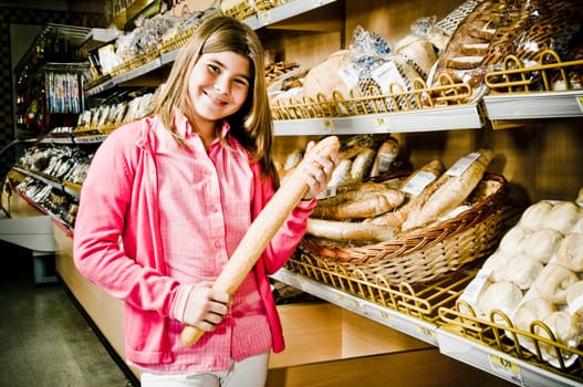 Girl holding a loaf of bread in a supermarket