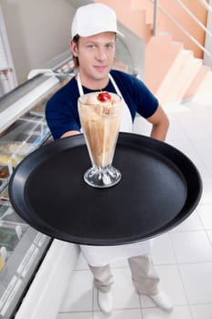 Ice cream seller holding a tray with a glass of ice cream