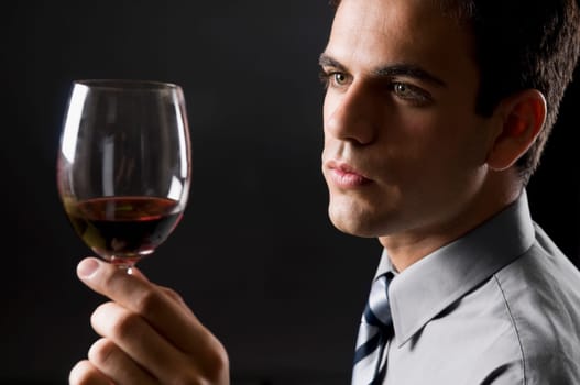 Businessman examining a glass of red wine