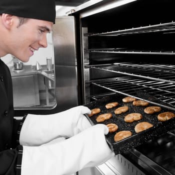 Chef taking out a tray of cookies from an oven