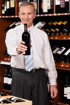 Businessman showing a wine bottle in a bar