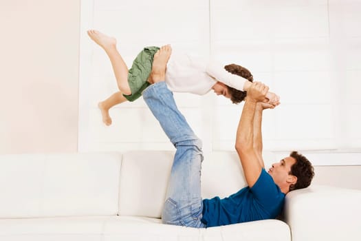 Man playing with his son on a couch
