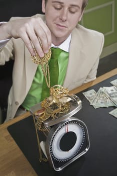Businessman weighing gold jewelry