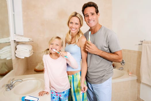 Family brushing teeth in the bathroom