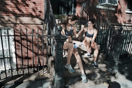 Woman looking at her friend flexing muscle and smiling