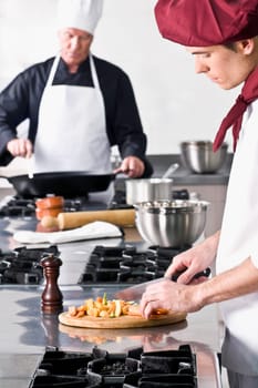Two chefs cooking food in the kitchen
