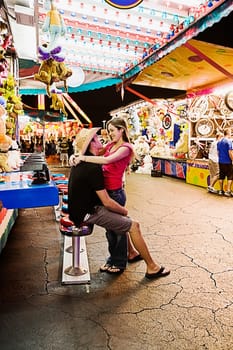 Teenage couple embracing each other in an amusement park