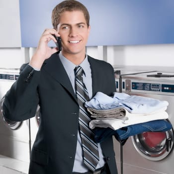 Businessman talking on a mobile phone in a laundromat