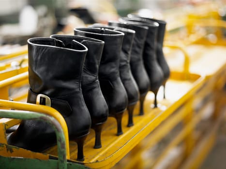 Close_up of leather boots on a shelf in a factory