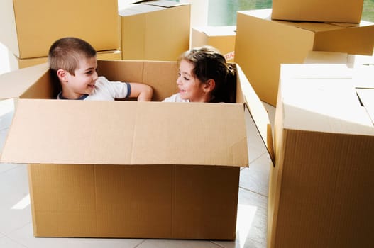 High angle view of a boy and a girl smiling in a cardboard box