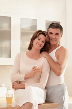 Couple drinking juice and romancing in the kitchen