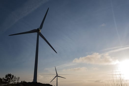 Wind energy turbines, in a landscpae over a beautiful blue sky
