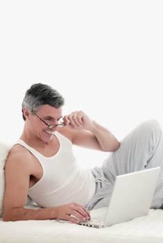 Man working on a laptop on the bed