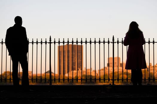 Silhouette of a man and a woman standing near a railing with buildings in the background, Central Park, Manhattan, New York City, New York State, USA