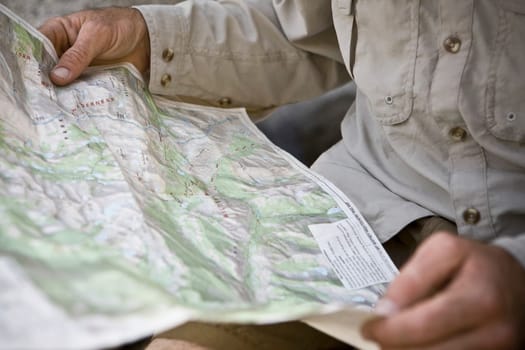 Mid section view of a hiker holding a map