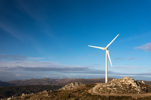Wind energy turbines, in a landscpae over a beautiful blue sky