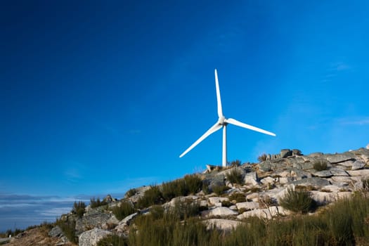 Wind energy turbines, in a landscpae over a beautiful blue sky