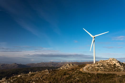 Wind energy turbines, in a landscpae over a beautiful blue sky