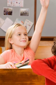 Schoolgirl raising her hand in a classroom