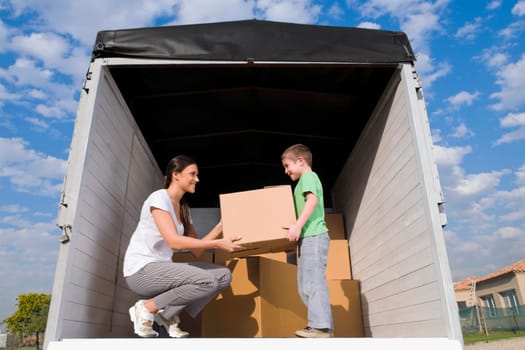 Low angle view of a young woman with her son carrying cardboard boxes